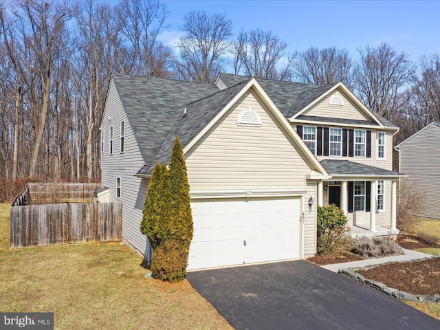 traditional home with a garage, aphalt driveway, roof with shingles, fence, and a front lawn