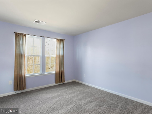 carpeted empty room featuring visible vents and baseboards