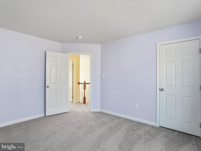 unfurnished bedroom featuring carpet flooring and baseboards