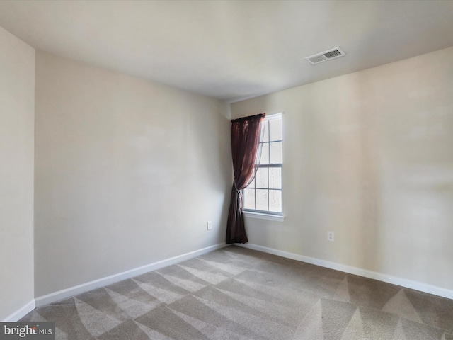 empty room with light colored carpet, visible vents, and baseboards