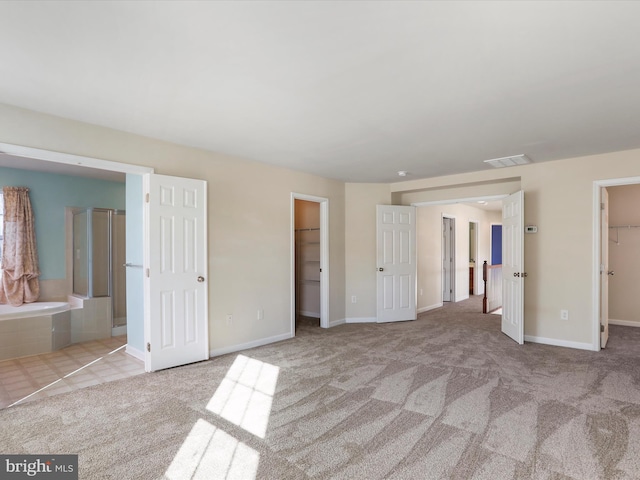 unfurnished bedroom with baseboards, visible vents, a spacious closet, carpet flooring, and a closet