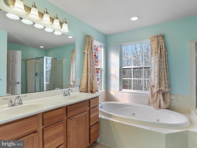 full bath featuring double vanity, a stall shower, a sink, and a jetted tub