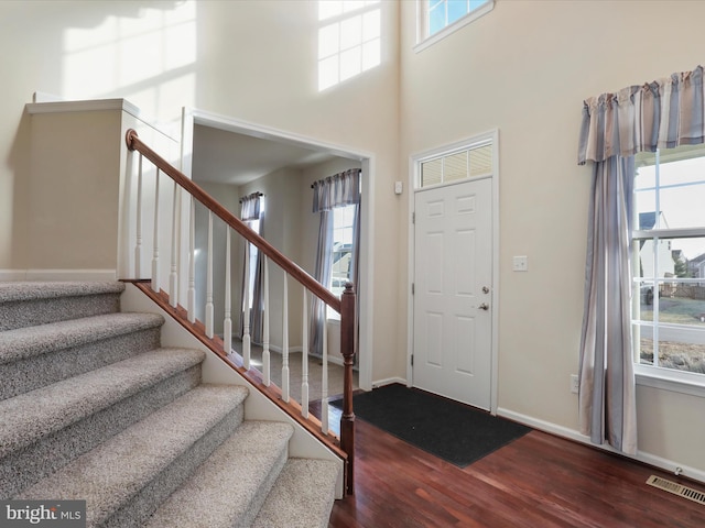 foyer entrance featuring a healthy amount of sunlight, visible vents, and wood finished floors