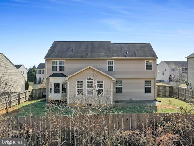 back of property with a lawn, a patio area, and a fenced backyard