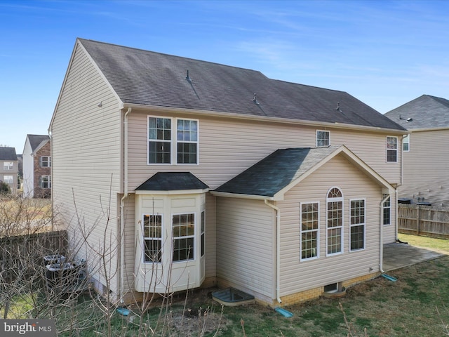 rear view of house with roof with shingles and fence