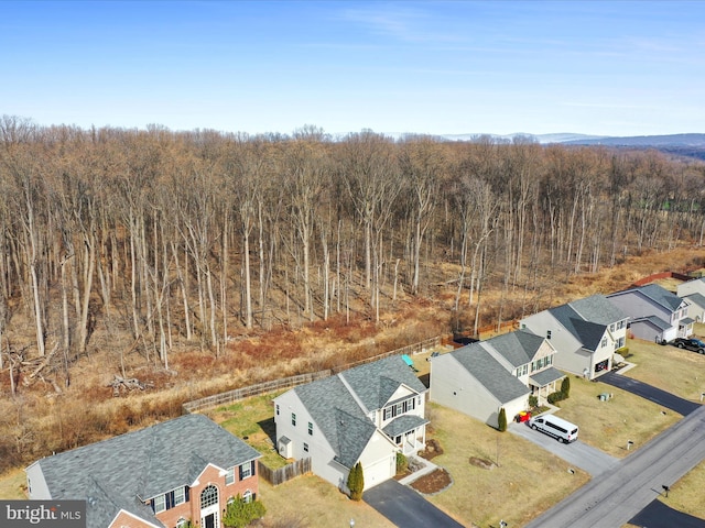 drone / aerial view featuring a residential view and a view of trees