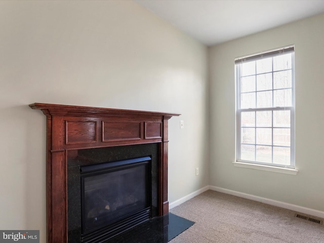 details with a fireplace with flush hearth, visible vents, carpet floors, and baseboards