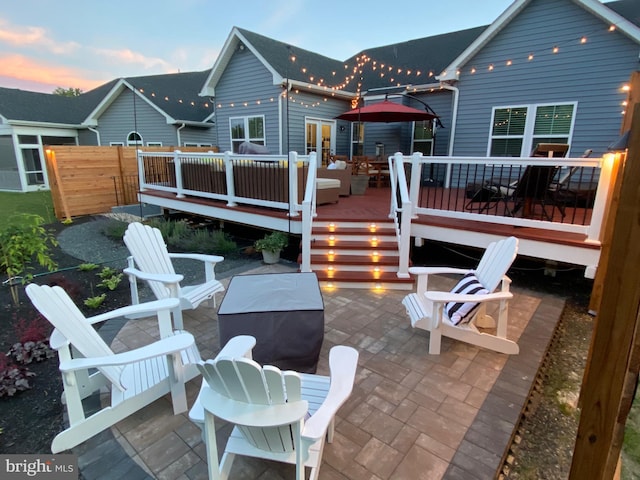 back of house at dusk with a patio and fence