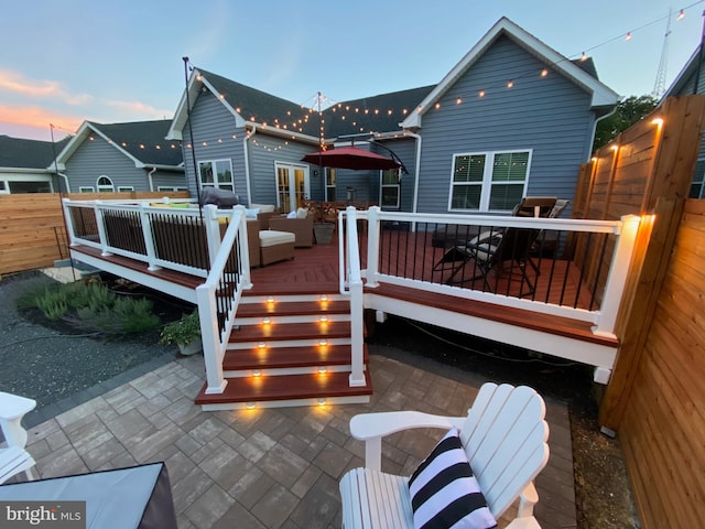 back of house featuring fence, a deck, and a patio