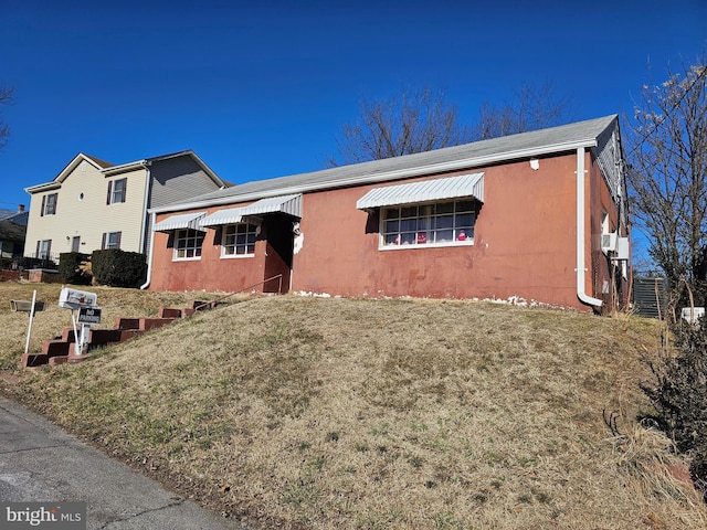 single story home featuring central AC unit, a front yard, and stucco siding