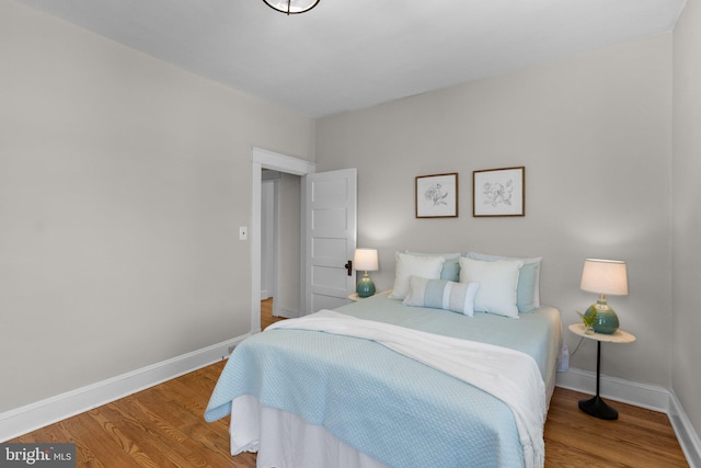 bedroom with baseboards and wood finished floors