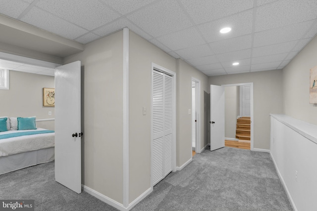 hallway with recessed lighting, carpet flooring, baseboards, and a drop ceiling