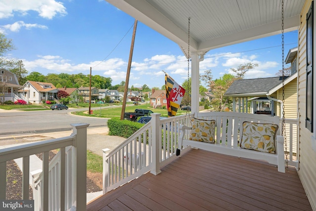 wooden deck with a residential view and covered porch