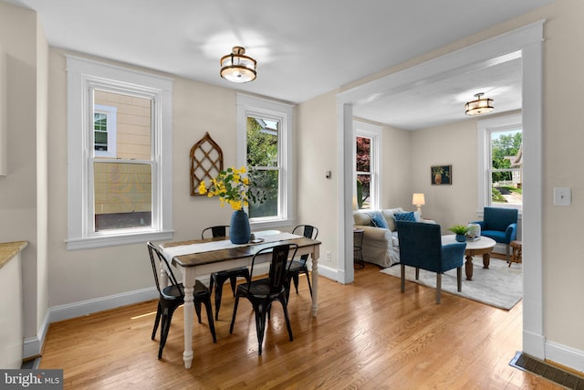 dining area featuring baseboards, light wood-style flooring, and a wealth of natural light