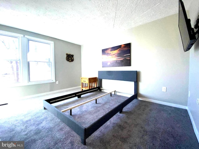 bedroom with a textured ceiling, carpet flooring, and baseboards