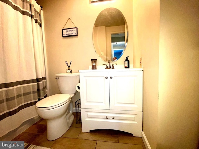 bathroom featuring toilet, tile patterned flooring, baseboards, and vanity