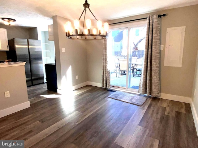 unfurnished dining area with an inviting chandelier, electric panel, baseboards, and dark wood-style flooring