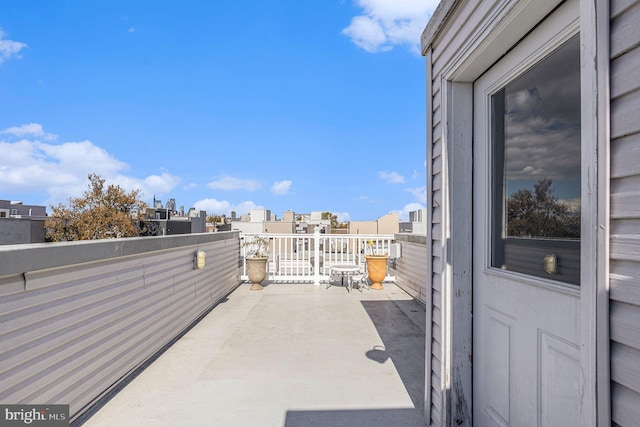 view of patio / terrace with a view of city and a balcony