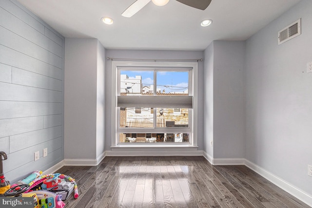 interior space with a ceiling fan, baseboards, visible vents, and wood finished floors