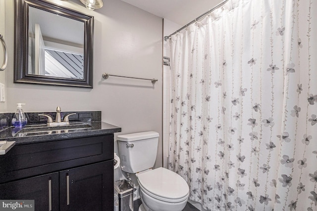 full bath featuring toilet, a shower with shower curtain, and vanity