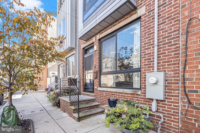 view of exterior entry with brick siding