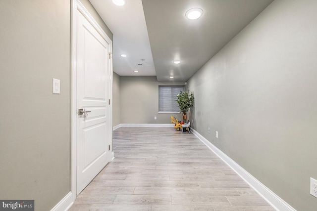 hallway with recessed lighting, light wood-style flooring, and baseboards