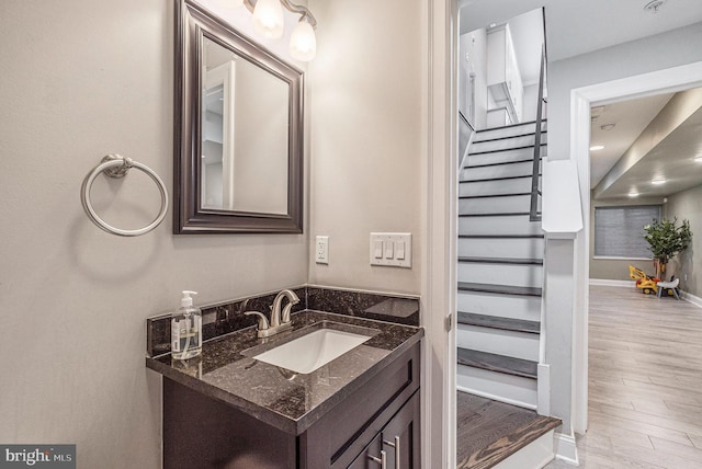 bathroom with baseboards, wood finished floors, and vanity