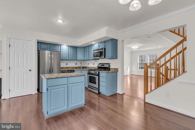 kitchen with dark wood-style floors, blue cabinetry, appliances with stainless steel finishes, and a center island