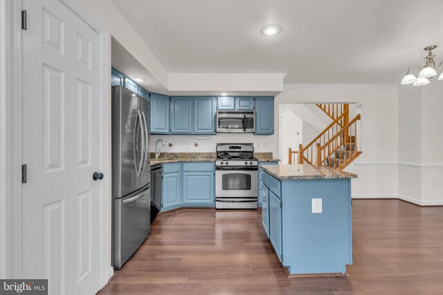 kitchen with light stone counters, baseboards, dark wood-style flooring, stainless steel appliances, and blue cabinets