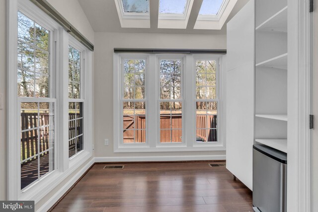 unfurnished sunroom with a skylight and visible vents