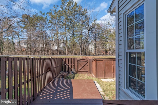wooden terrace featuring fence and a gate