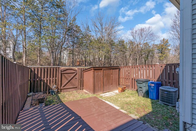 wooden deck with central air condition unit, a gate, and a fenced backyard
