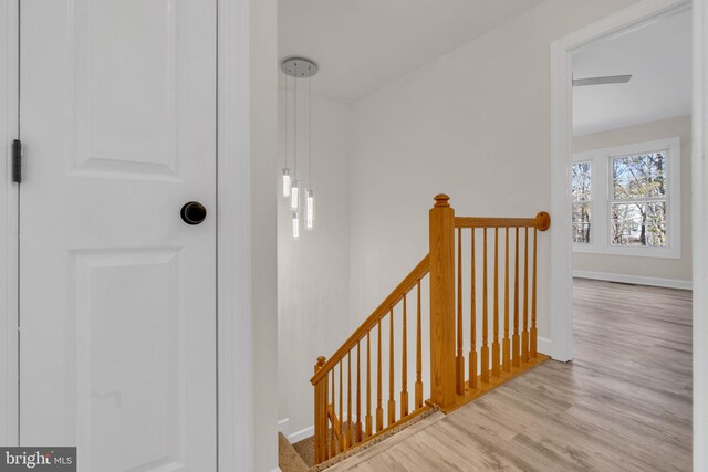 staircase featuring wood finished floors and baseboards