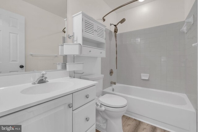 bathroom with toilet, vanity, bathing tub / shower combination, and wood finished floors