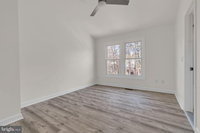 unfurnished room featuring a ceiling fan, wood finished floors, visible vents, and baseboards