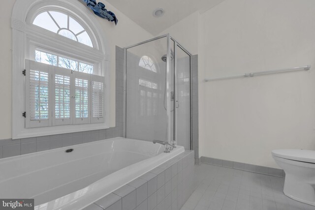 full bath with tile patterned flooring, baseboards, toilet, a stall shower, and a bath