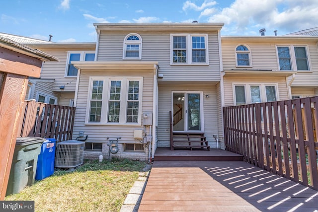 townhome / multi-family property featuring central air condition unit and fence