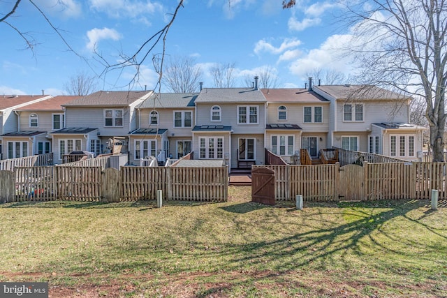 rear view of property featuring a gate, a yard, a fenced backyard, and a residential view