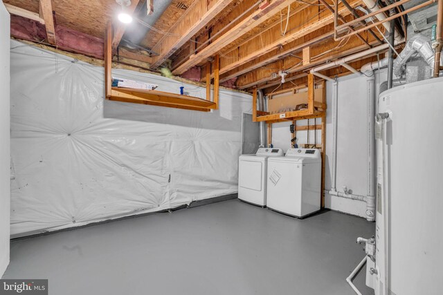 unfinished below grade area featuring washing machine and dryer and water heater