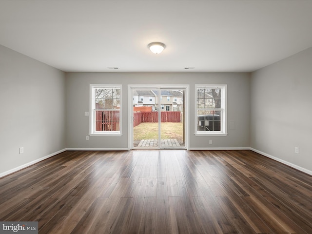 unfurnished room featuring dark wood-type flooring and baseboards