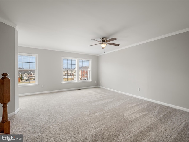 carpeted spare room featuring a healthy amount of sunlight, baseboards, and ornamental molding