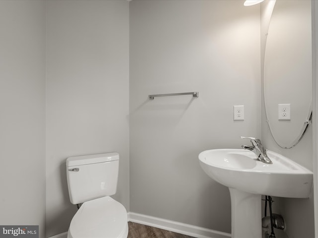 bathroom with toilet and baseboards