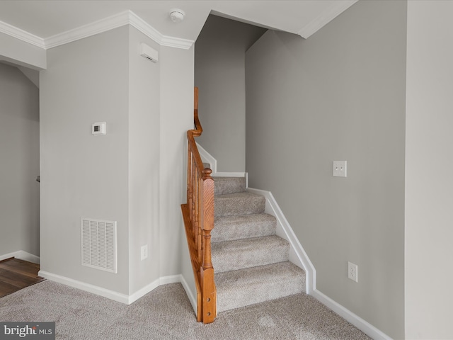 staircase featuring visible vents, crown molding, and baseboards