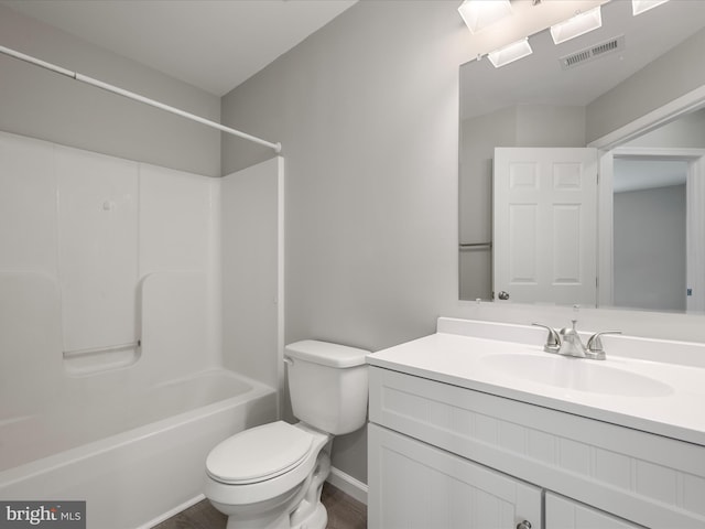 full bathroom featuring visible vents, bathing tub / shower combination, toilet, wood finished floors, and vanity