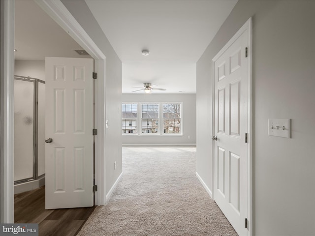 corridor featuring carpet floors, baseboards, and visible vents