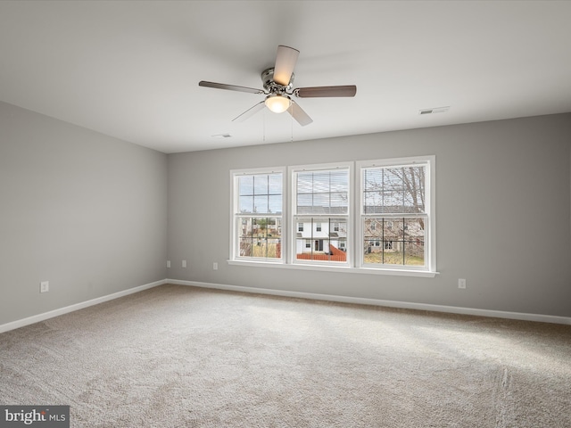 unfurnished room with ceiling fan, carpet flooring, visible vents, and baseboards