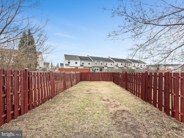 view of yard with a fenced backyard and a residential view