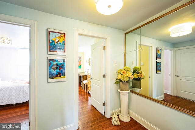 hall with dark wood-style floors and baseboards