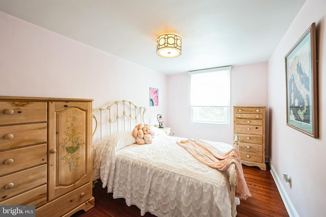 bedroom with dark wood finished floors and baseboards