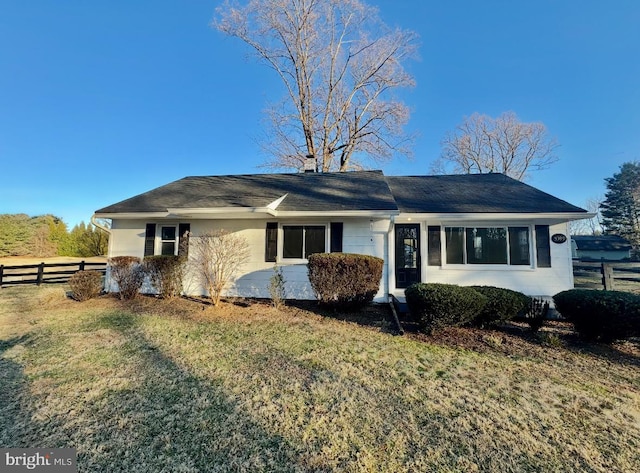 single story home with a chimney, fence, and a front lawn